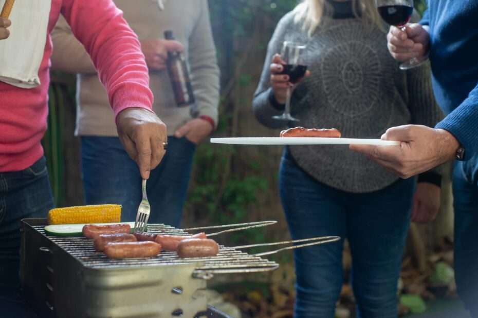Friends enjoying drinks at a backyard party with outdoor lights and relaxed seating