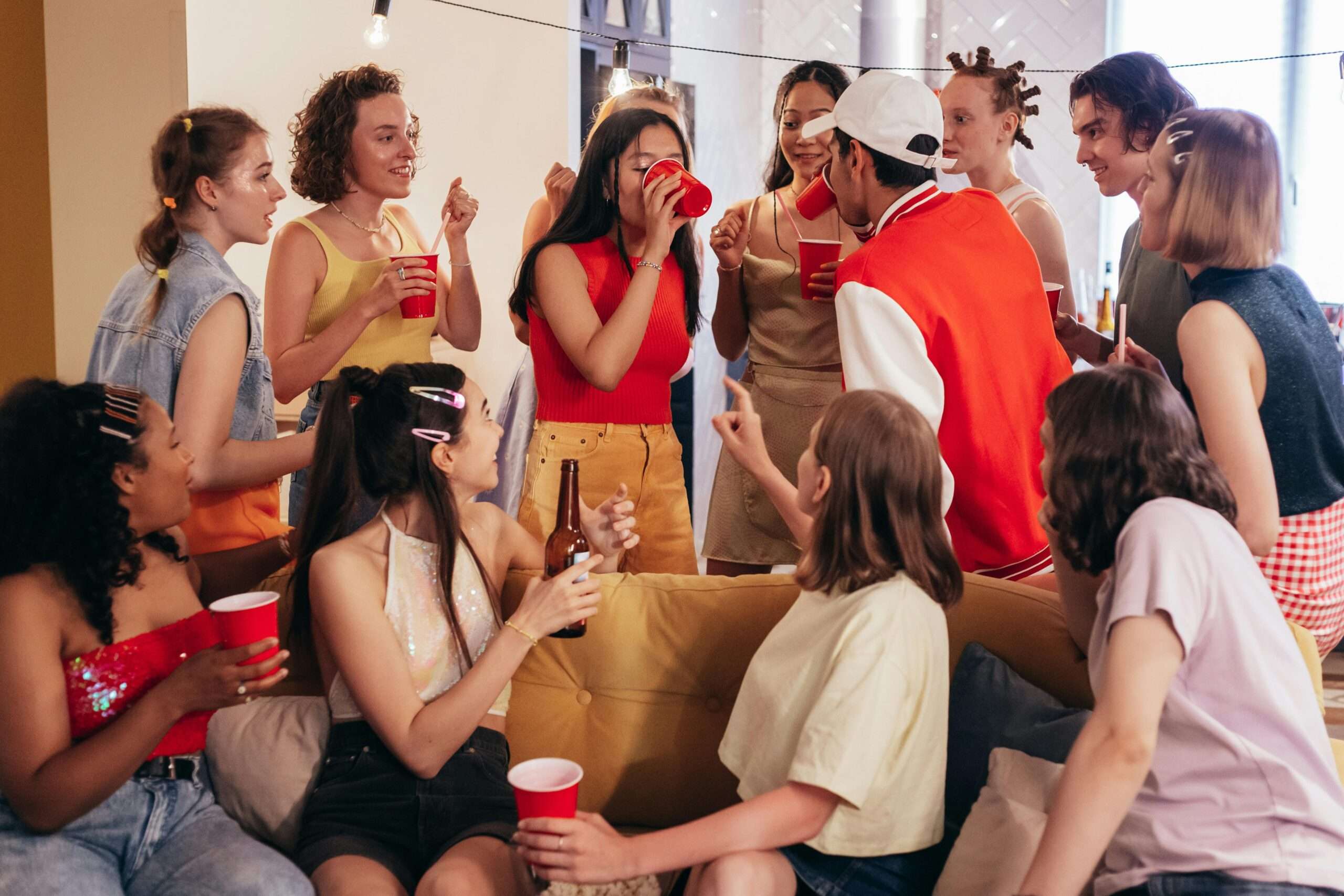 "College party starter pack with red cups, beer pong, Bluetooth speaker, and games on a table"